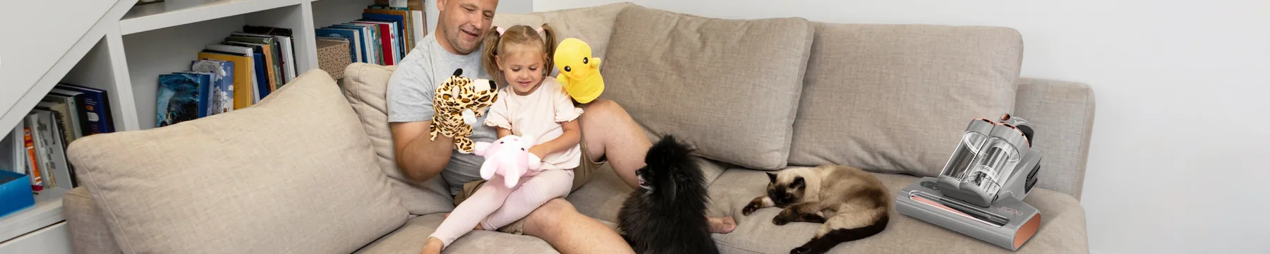 Family relaxing on a sofa beside a Jigoo fabric-care vacuum